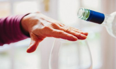 closeup of hand covering top of wine glass