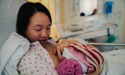 Mom nursing newborn baby in hospital bed