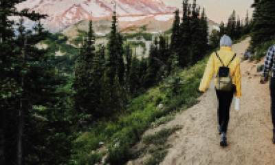 Two people hiking a trail near a mountain