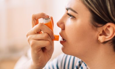 Woman holds inhaler up to her mouth