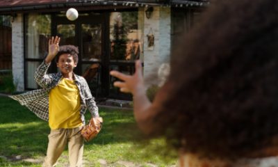 Boy and girl play catch with a baseball in yard