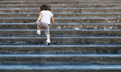 Small child climbs steps outside