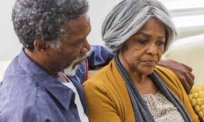 Man puts arm around the shoulder of a sad woman