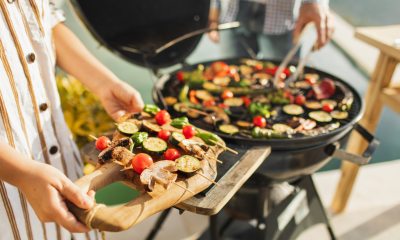 Hands of woman holding tray of veggie kabobs for grilling