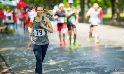 woman wearing race bib jogs along the course outside