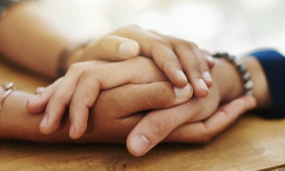 Close up of hands clasped in support