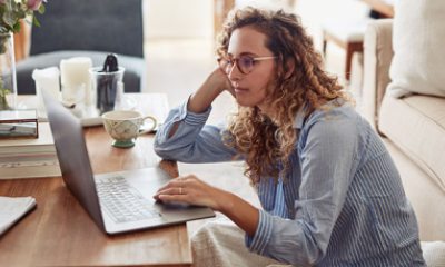 Young professional woman stares at laptop with defeated look.