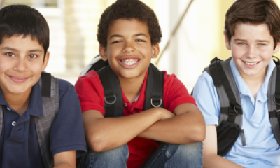Three smiling boys weasring backpacks
