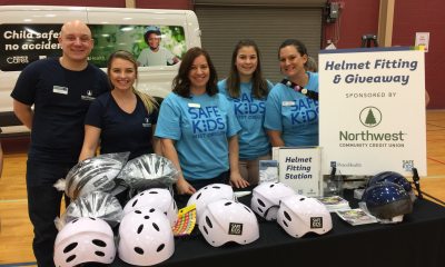 A team of PeaceHealth volunteers smiles at a helmet fitting event for "Safe Kids"