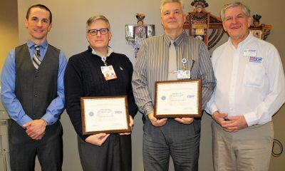 A group of caregivers hold certificate awards
