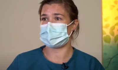 A masked nurse looks on 