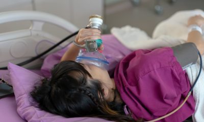 A young patient holds a nitrous oxide mask to her face