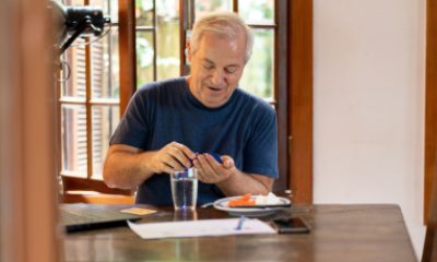 Man takes a medication while sitting at a table