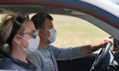 man and woman wearing masks in the car