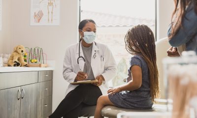 Young girl and her mother visit with a pediatrician
