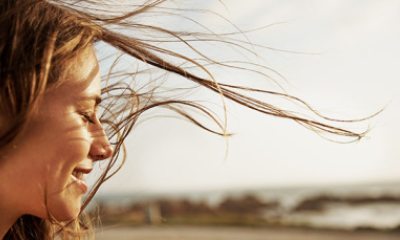 A woman smiles as her hair gently sways in the wind