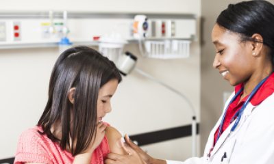 Young girl getting vaccine from doctor