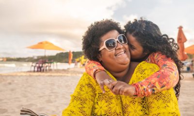 Daughter kisses mom's cheek at beach
