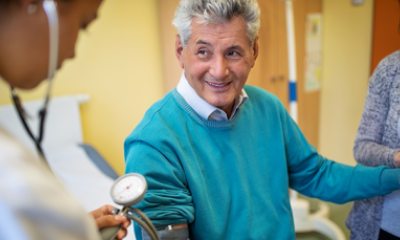 Nurse takes blood pressure of older man