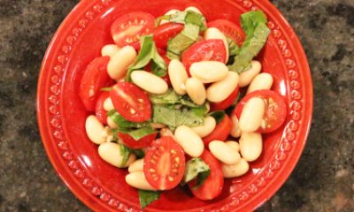 Mediteranean bean salad in an orange bowl