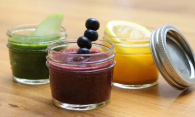 3 fruit adorned juice smoothies in glass containers