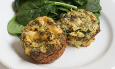 Egg stuffed mushrooms and baby spinach on a white plate