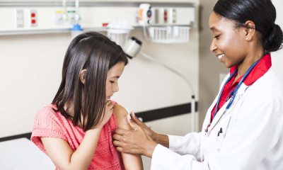 A health care provider administers a vaccine to a young girl