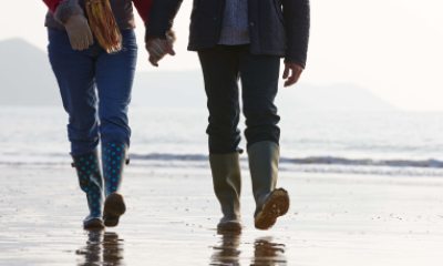 A couple walking on the beach holding hands