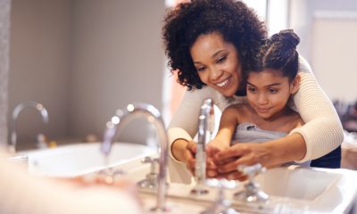 A mom showing her daughter how to wash hands properly