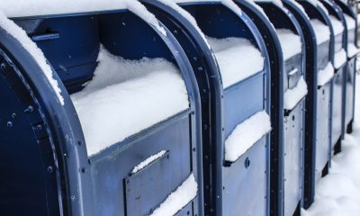 A row of snow covered postal boxes