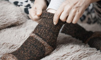 Close-up of hands puling wool socks up over feet and ankle