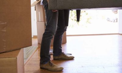 Close-up of  the legs of a person lifting a couch