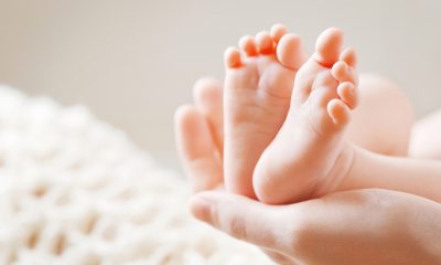 Adult hand holding a baby's feet