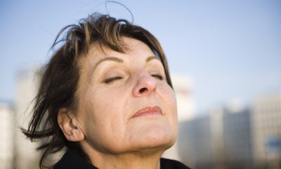 A woman closing her eyes and holding her face up towards the sky