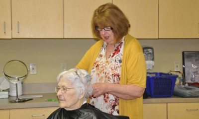PeaceHealth volunteer trims the hair of nursing home resident