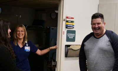 Wound Center staff and John share a laugh outside hyperbaric room