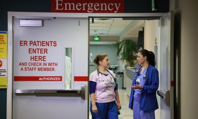 Two nurses chat at the emergency room door entrance