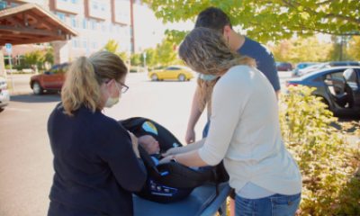 A certified child passenger safety technician instructs parents how to properly buckle their newborn into her car seat before the family leaves PeaceHealth Sacred Heart Medical Center at RiverBend in Springfield, Ore.