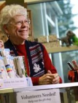 A smiling volunteer greets visitors from the Ketchikan Medical Center gift shop counter