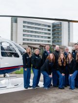 The Southwest Medical Center Trauma team stands on the helipad next to a helicopter