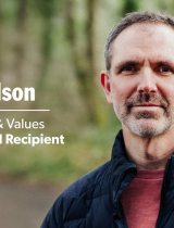 Brian Nelson outside on a trail in a forest