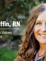 Tricia Griffin outside in front of green trees and grass