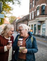 Two people joyfully talk while walking outside 