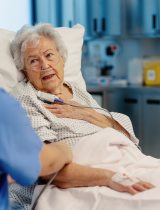 Nurse talks to a woman in a hospital bed