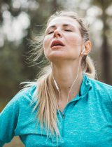 Exhausted runner with eyes closed, face tilted up