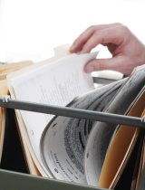 Hands going through documents in a filing cabinet