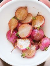 Bowl of red potatoes garnished with an herb