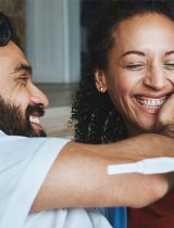 A couple smiles while looking at results on an instant pregnancy test