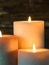 Three lit white candles providing ambient light