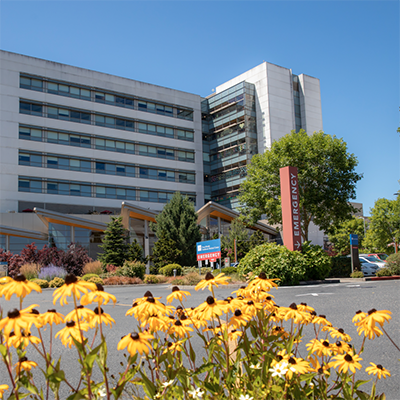 PeaceHealth Southwest Medical Center building in the background, with sunflowers growing in the foreground